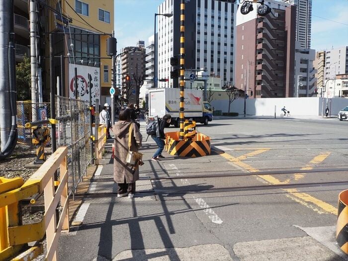 踏切だった場所を通る人々