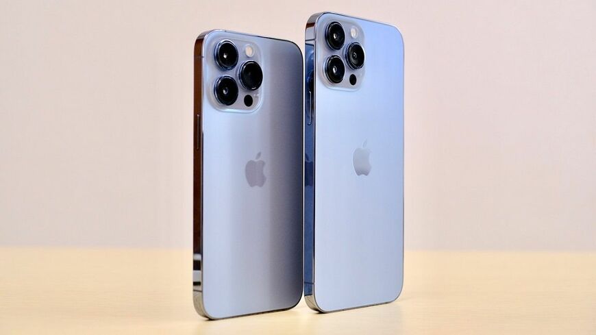 iPhone 13 Pro（左）とiPhone 13 Pro Max（右）。いずれも新色となるシエラブルー。淡い青は緑っぽくも、紫っぽくもある独特の表情を見せる。昨年からさらに大型化したカメラは強烈な印象だ（筆者撮影）