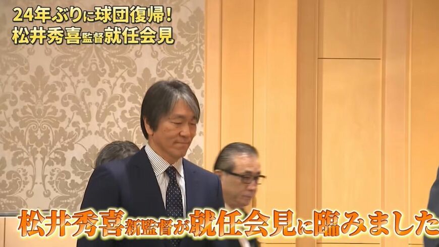 フラッシュの中、壇上にのぼる松井秀喜新監督