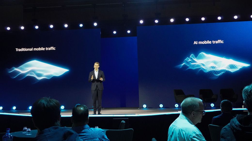 Nokiaのプレスイベントで、従来のモバイルトラフィック（左）とAIモバイルトラフィック（右）の違いを示すHotard CEO。AIのトラフィックは変動が大きく不規則だと説明した（写真：筆者撮影）