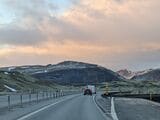 帰りの空港に向かう道を運転してくれた。禿げた大地に見えて、雪が溶けた下からは青い草が顔を出していた（写真：筆者撮影）