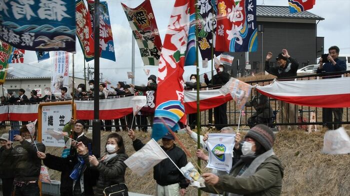 大漁旗を振って記念列車を歓迎する沿線の人々