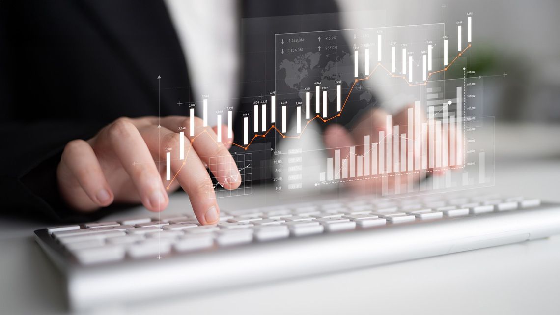 株価チャートとパソコンを操作する男性のイメージ