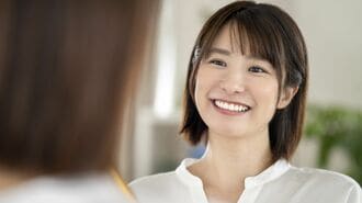 鏡を見て微笑む女性
