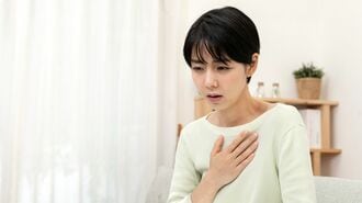 胸を押さえる女性