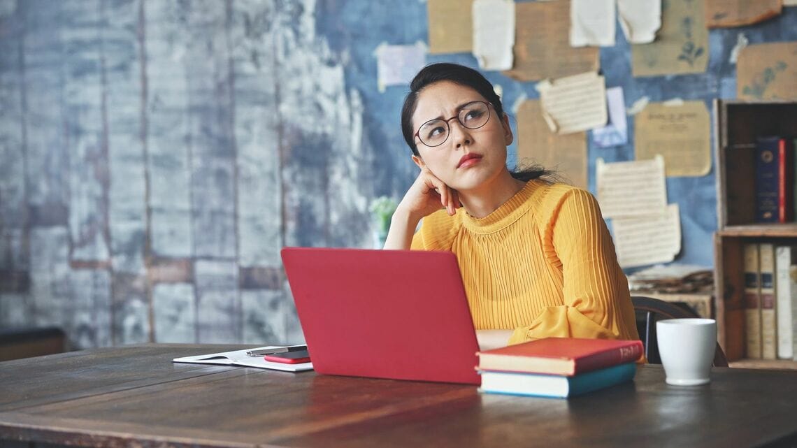 パソコンの前で悩む女性