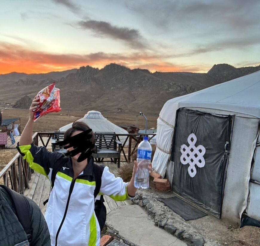 モンゴルで「かっぱえびせん」を握りしめる筆者。アホヅラなので黒塗りしました。ちなみにかっぱえびせんは、このテントを所有しているオーナー夫婦にプレゼントしました（筆者撮影）