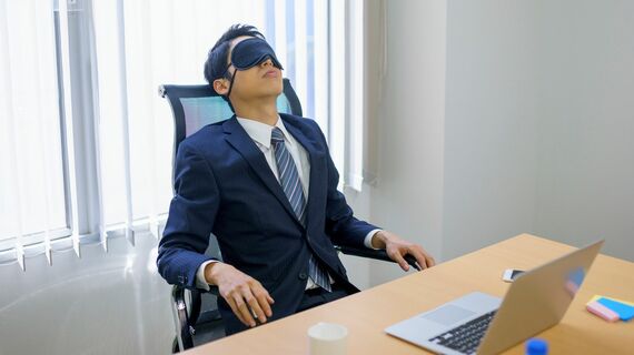 アイマスクをして休息する男性