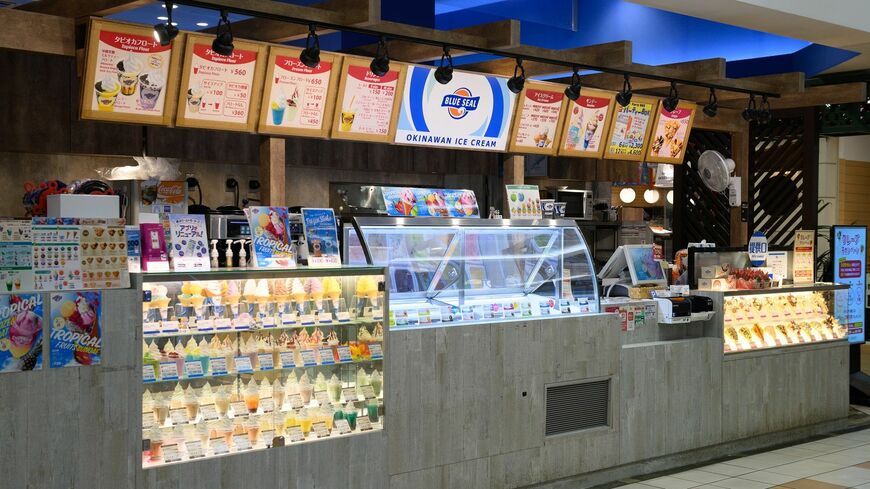 最強のご当地アイス、ブルーシールアイスクリーム。店頭に並ぶ20数種類の商品のうち、8種類以上は沖縄産素材を用いたフレーバーだ。写真は直営店として首都圏におけるフラッグシップ店となっている、横浜ワールドポーターズ店（撮影：今祥雄）