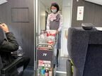車内販売のカートを押す客室乗務員。