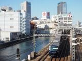 平沼橋から見た横浜駅西口付近。高島屋と相鉄ジョイナス、そして左側の帷子川沿いに相鉄ムービルが見える。相鉄線の電車は最新の13000系（編集部撮影）