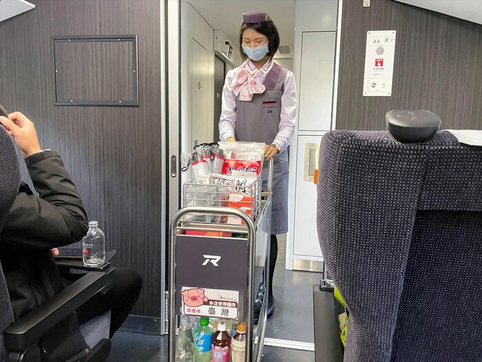 車内販売のカートを押す客室乗務員。