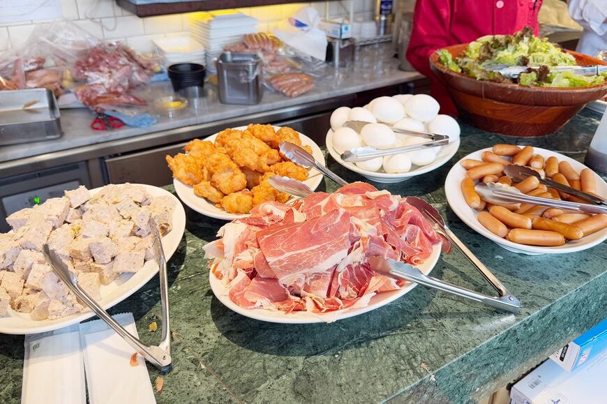 バルマルシェコダマのモーニングビュッフェ。生ハム、ソーセージ、パン、サラダなどが並ぶ（筆者撮影）