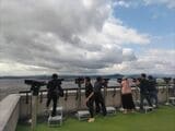 双眼鏡をのぞき込む観光客（著者撮影）
