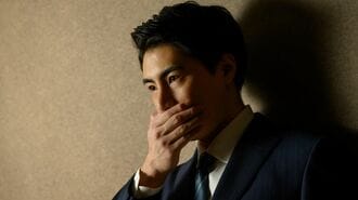 考え込む表情のスーツ姿の男性