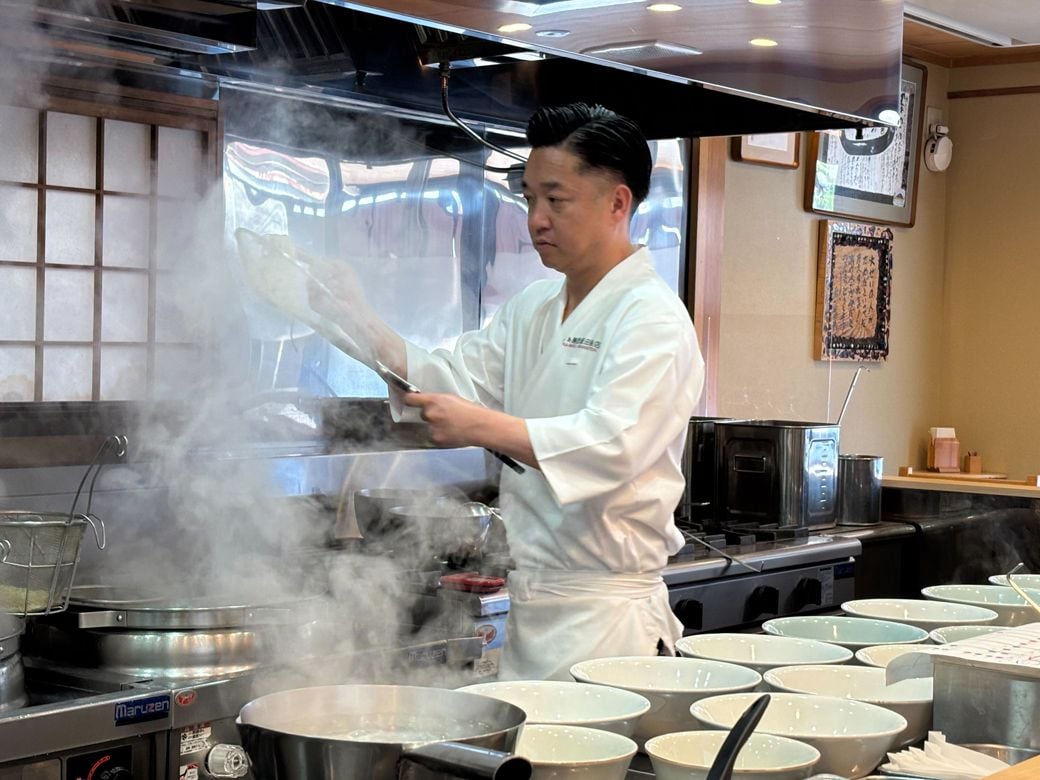 調理中の飯田さん（筆者撮影）
