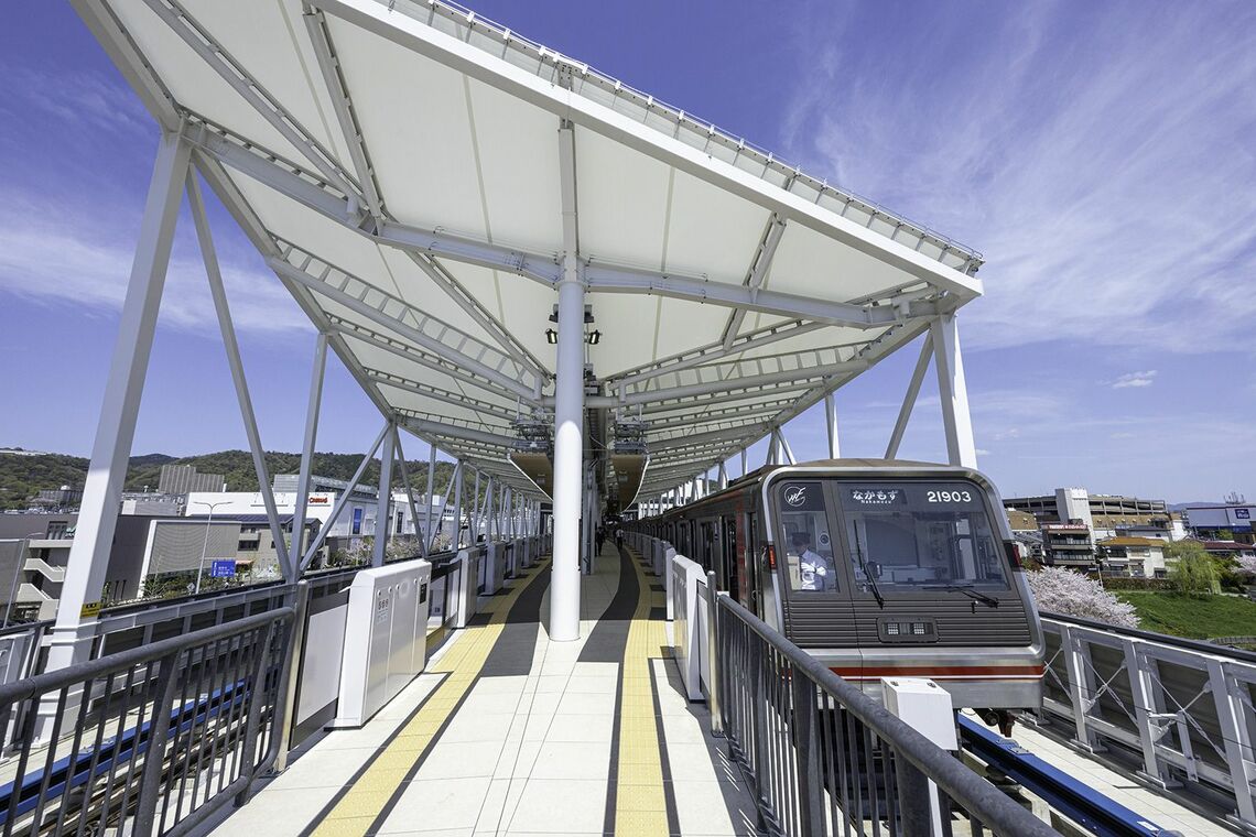 箕面萱野駅のホーム上屋は幕屋根で明るい。停車中の車両は大阪メトロの20系で特徴的な前面スタイルのこの電車も30年選手となった（写真：松本洋一）