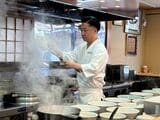 調理中の飯田さん（筆者撮影）