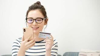 スマートフォンとカードを持つ人物