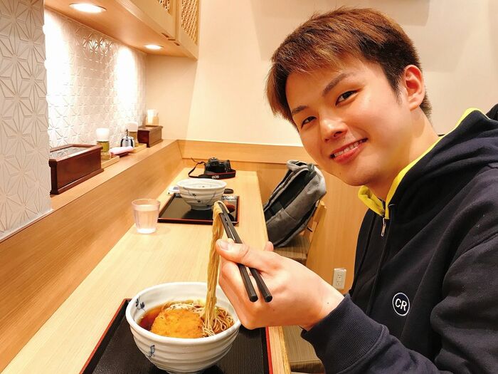 ロボットが作ったそばをおいしそうに食べる大久保さん