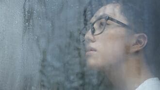窓辺で思索する男性
