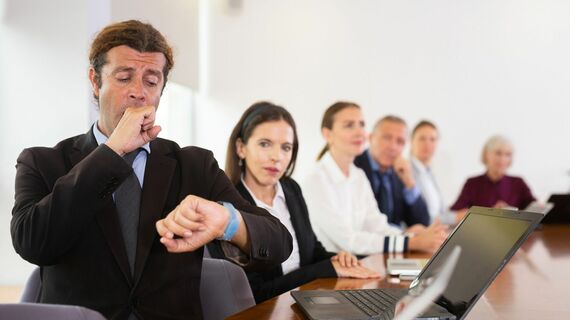 会議中にあくびをするビジネスパーソン