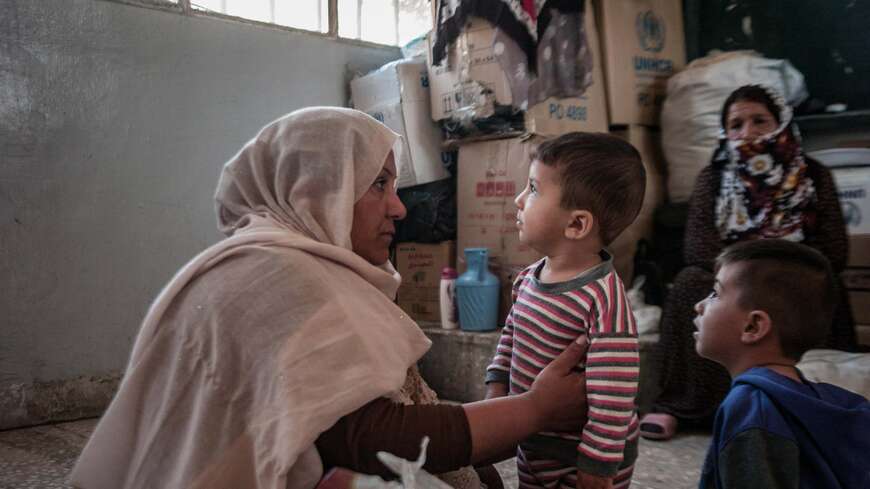 ミリアムは、ラス・アル・アインからハサカに逃れ、仮の避難所として学校に収容されています。各学校には少なくとも20家族が収容されており、約150から200人が一緒に暮らしています。ミリアムは、ラス・アル・アインから逃れる際に持ってきたのはわずか2万シリアポンド（約15米ドル）だけで、それが彼女と家族が持っていたすべての財産です。ミリアムと彼女の家族は、学校での生活に水と衛生、そして子供たちが病気になった場合の薬が不足していることを心配しています。学校にはトイレは3つしかなく、体を洗って清潔に保つ場所もありません。ミリアムの基本的な願いは、まともな温かい食事をつくる調理器具、水、衛生設備が提供されることです（©️Jake Simkin）