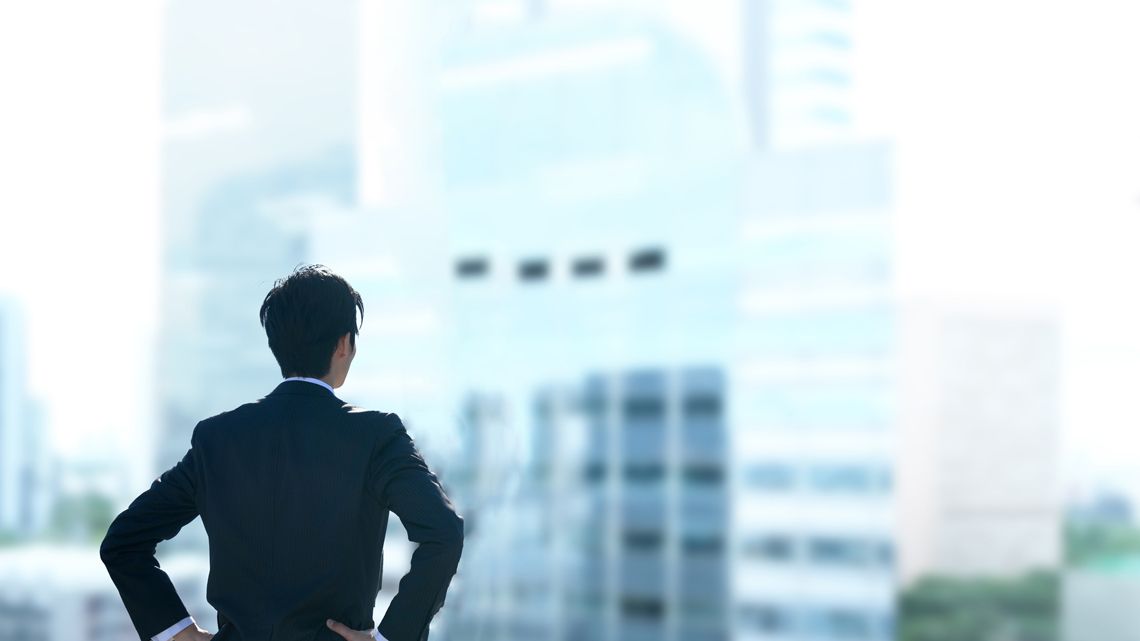 遠くを見つめる若いビジネスパーソン