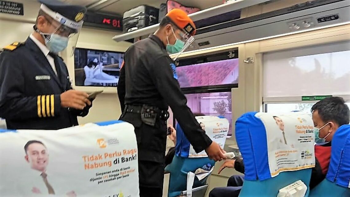 インドネシア鉄道の列車内で、乗客の検温のため車内を巡回する軍人（筆者撮影）