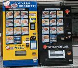 ケンミンが最初に本社前に設置した自動販売機（左）。2023年に、グルテンフリーラーメンの自動販売機（右）も設置された（写真提供：ケンミン）