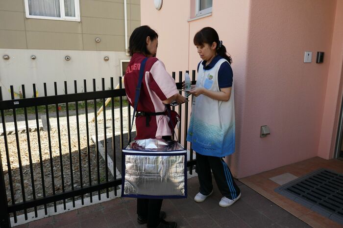 保育園の職員が商品を受け取る。決済は現金の受け渡しのみ