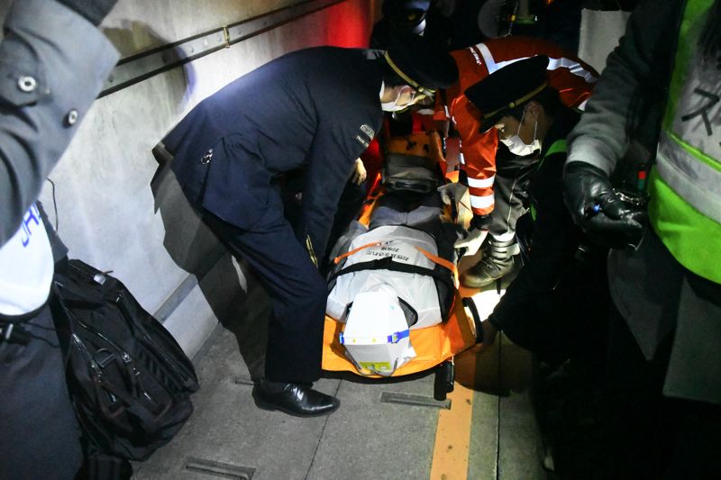 担架に乗せられたけがをした乗客（記者撮影）
