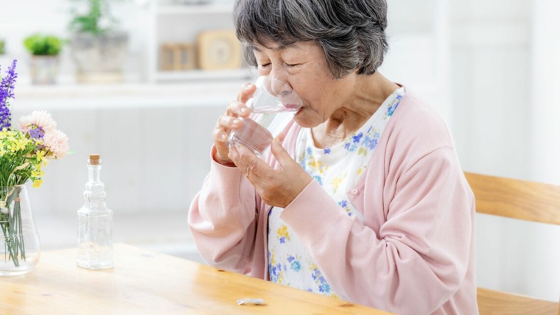 薬を飲むおばあさん