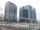 2026年3月に開業予定の「大井町トラックス」のビルと山手線の車両基地（記者撮影）