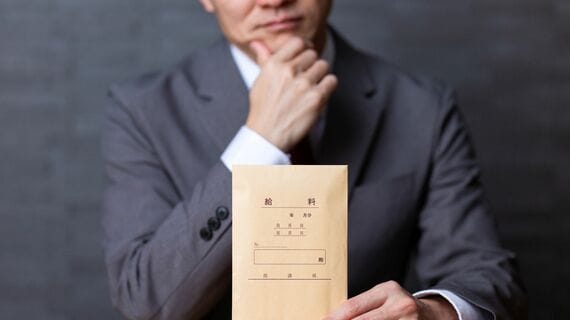 給料袋を持って悩む男性