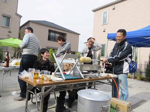 コミュニティ賃貸パルコカーサの敷地内で行われるバーベキューの準備は入居者全員で行う。写真一番右が、オーナー3兄弟の長兄、田口昌宏氏（写真：筆者撮影）