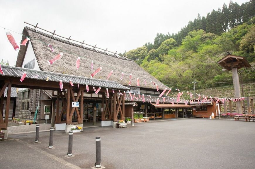 茅葺屋根があたりの風景と調和する道の駅酒谷。訪れたのは4月末だったため、こいのぼりが飾られていた（筆者撮影）