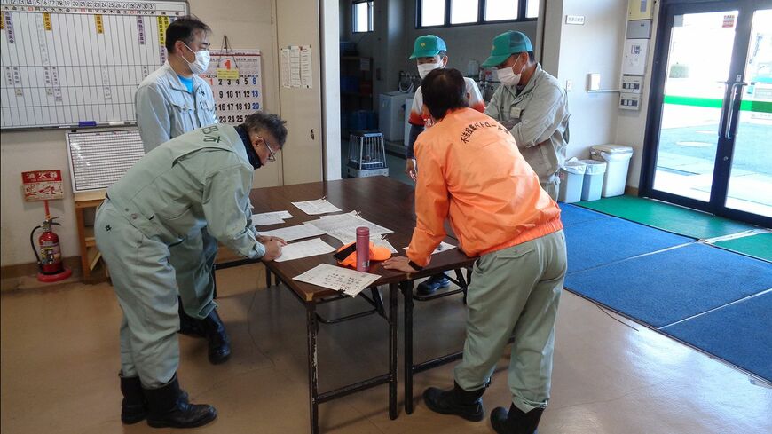 清掃事務所の玄関に特設された司令塔で指示を受ける清掃職員