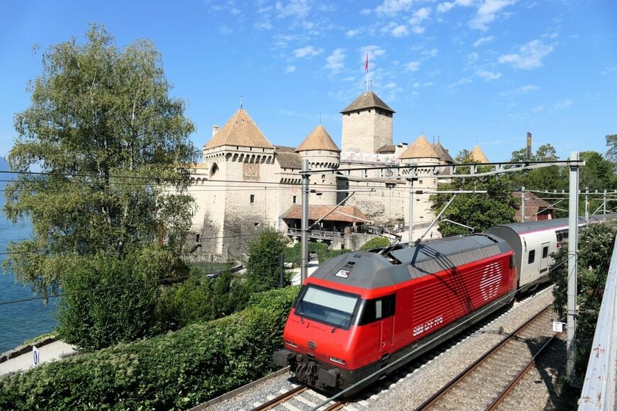 電気機関車の推す2階建てのインターシティがシオン城横を通過（筆者撮影）