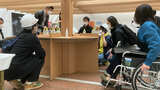 川崎駅前で行われた"バリアフル"レストランの様子。「2足歩行」の人は天井にぶつからないよう、ヘルメットをかぶっている（写真：公益財団法人日本ケアフィット共育機構提供）