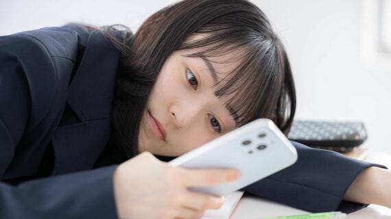 スマートフォンを見つめる女子高生