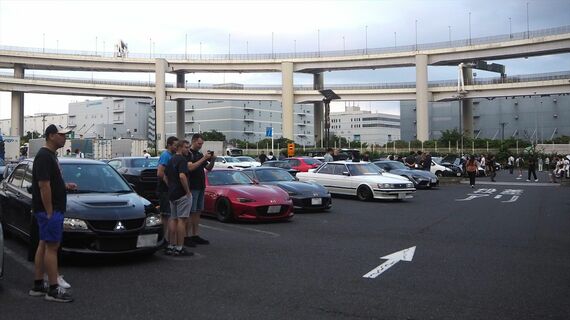 日本のスポーツカーや旧車にカメラを向ける外国人観光客（筆者撮影）