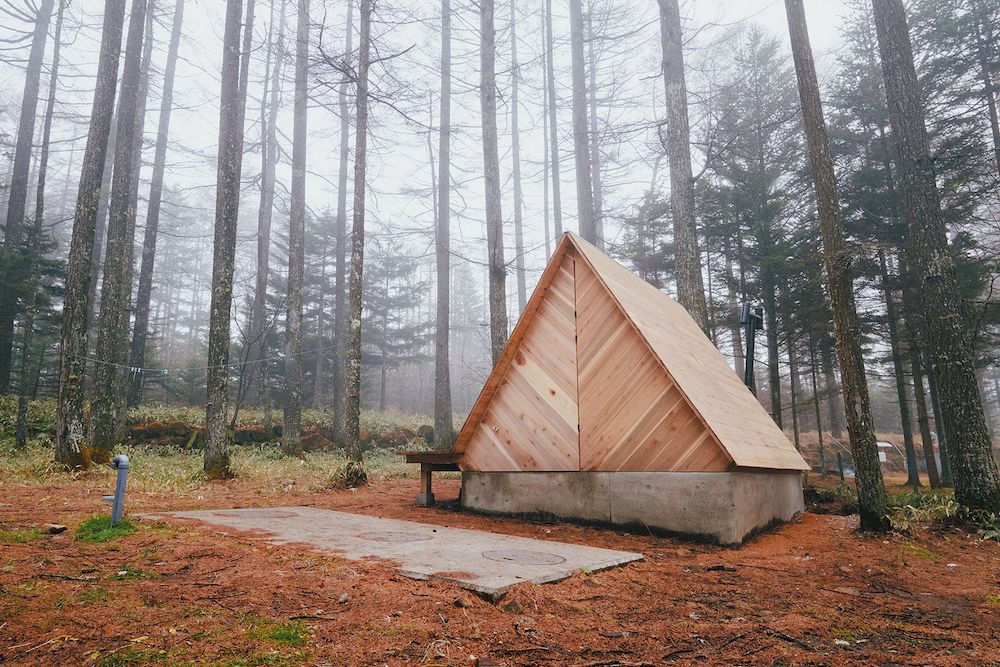 森に佇む三角形のサウナ小屋。塗装されておらず、これからの木材の色の変化も楽しみ（写真：『小屋の時間』）