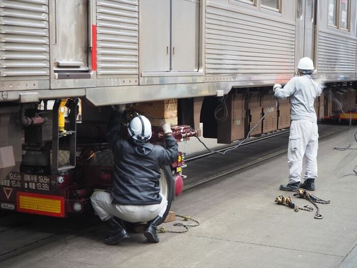 車体をトレーラーに固定する作業