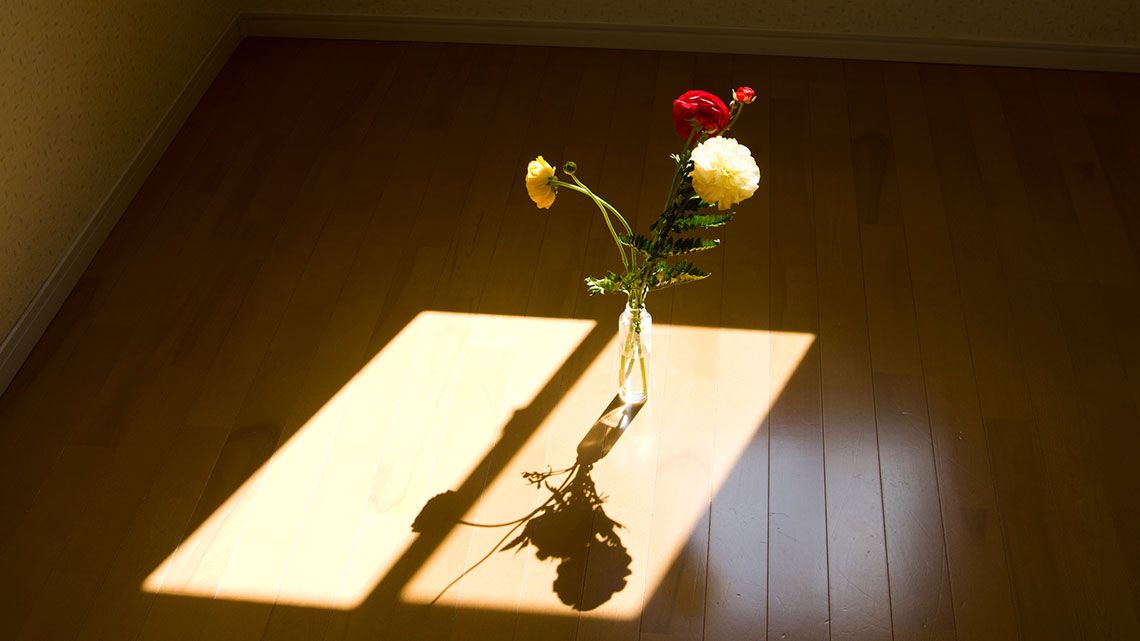 部屋の床に花瓶に入った花が置いてあります