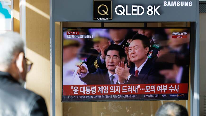 2024年12月18日水曜日、韓国・ソウルのソウル駅で、尹錫烈（ユン・ソンニョル）韓国大統領に関する報道がスクリーンに映し出されている（写真・ 2024 Bloomberg Finance LP）