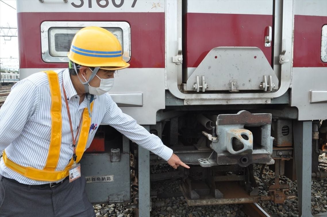 かつて電気連結器があった部分を指さす川鍋さん。