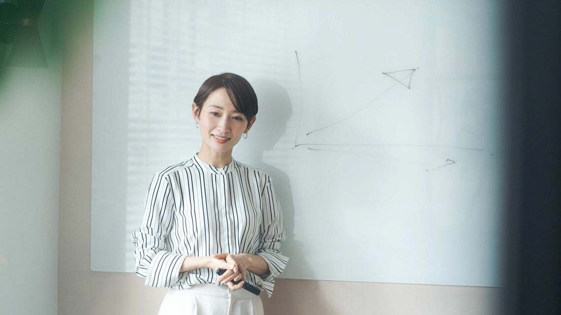ホワイトボードの前に立つ女性