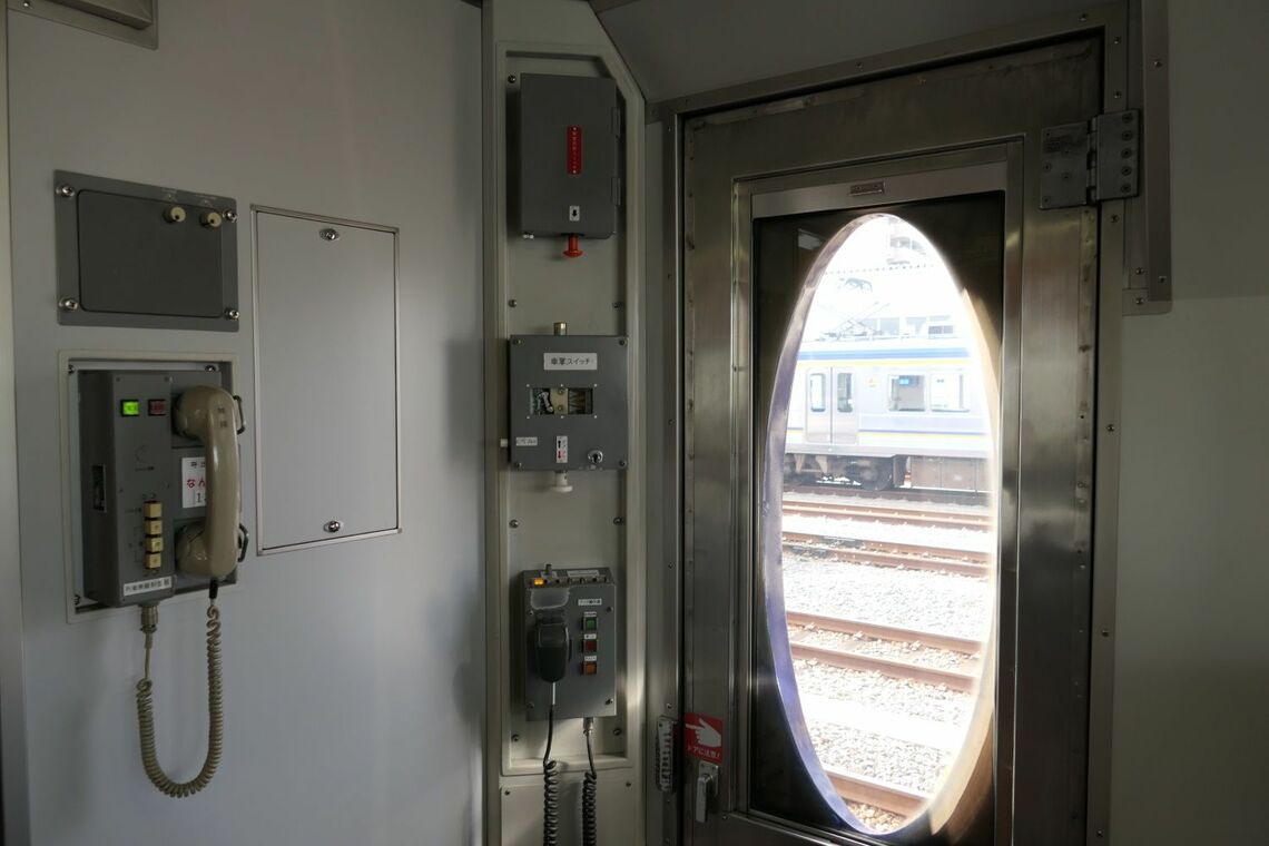 乗務員室の扉と車掌が扱う機器類（記者撮影）