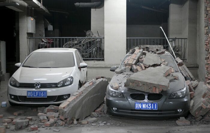 爆発による建物の崩壊でダメージを受けた乗用車